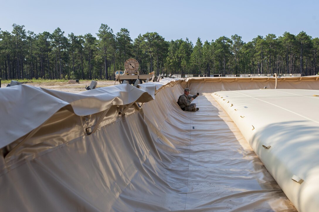 U.S. Army Reserve Spc. Dwayne Bentley, with the 431st Quartermaster Company, 103rd Expeditionary Sustainment Command, Battle Creek, Mich., measures the volume of product in a 50K bag during QLLEX 2017, July 21, at Fort Bragg, NC. QLLEX, short for Quartermaster Liquid Logistics Exercise, is the U.S. Army Reserve’s premier readiness exercise for fuel and water distribution. This year’s QLLEX is not only a full demonstration of the capability, combat-readiness, and lethality of America’s Army Reserve to put fuel and water where it is needed most – in the vehicles and hands of the war-fighter and maneuver units – but it also further exercises the interoperability of the U.S. Army Reserve alongside active Army and British Army logisticians. (U.S. Army Reserve photo by Timothy L. Hale) (Released)