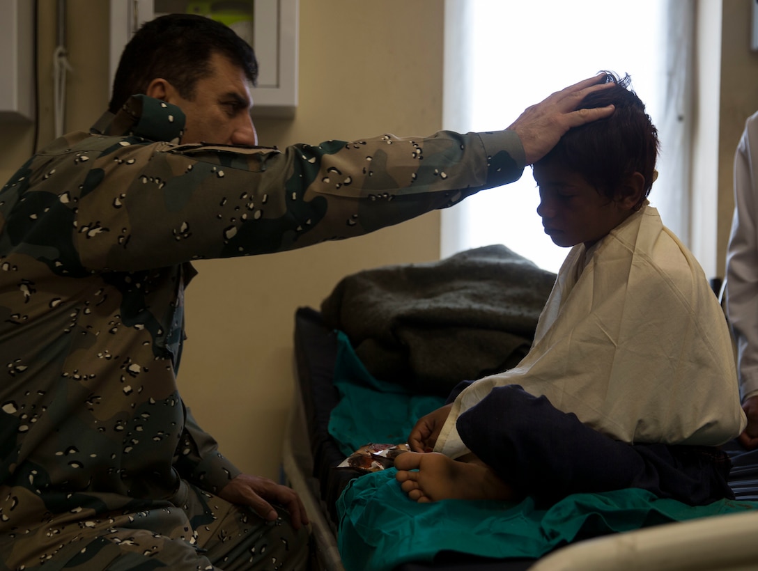 General Daud Ghulam Tarakhel, the commanding general of the 505th Zone National Police, pays a visit to the young boy who was injured during a Taliban rocket attack just outside of Bost Airfield, Afghanistan, July 20, 2017. (U.S. Marine Corps photo by Sgt. Justin T. Updegraff)