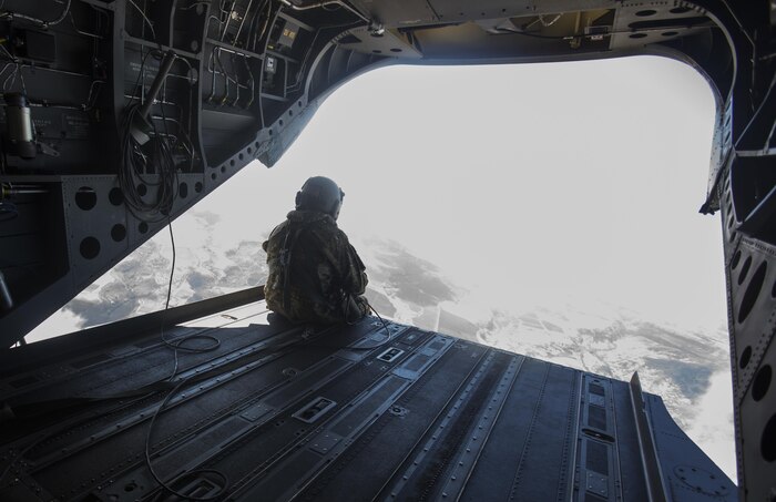 SCHOFIELD BARRACKS – A U.S. Army crew chief sits at the edge of a CH-47 Chinook helicopter ramp during a high altitude airborne jump at Schofield Barracks, July 14, 2017. Marines with 4th Force Reconnaissance Company trained with U.S. Army Special Forces to maintain proficiency in completing static line and high altitude free fall airborne jumps. (U.S. Marine Corps photo by Lance Cpl. Isabelo Tabanguil)