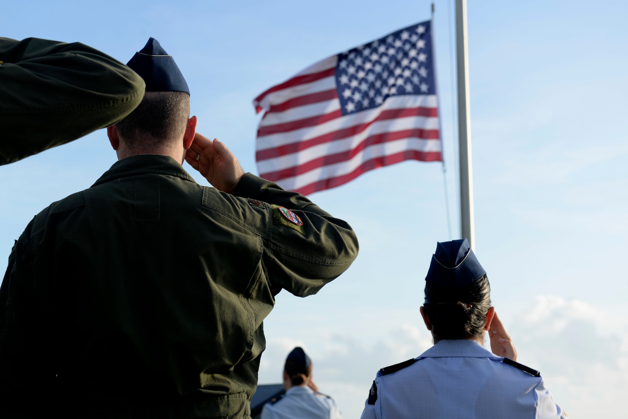 Attendees of the RAIDR 21 memorial ceremony salute during the National Anthem July 21, 2017, in Adelup, Guam. The monument honors the six B-52 Stratofortress crew members who lost their lives during a training mission July 21, 2008. The six aviators, from the 20th Expeditionary Bomb Squadron, were slated to participate in a flyover for Guam's Liberation Day Parade. (U.S. Air Force photo by Airman 1st Class Gerald R. Willis)