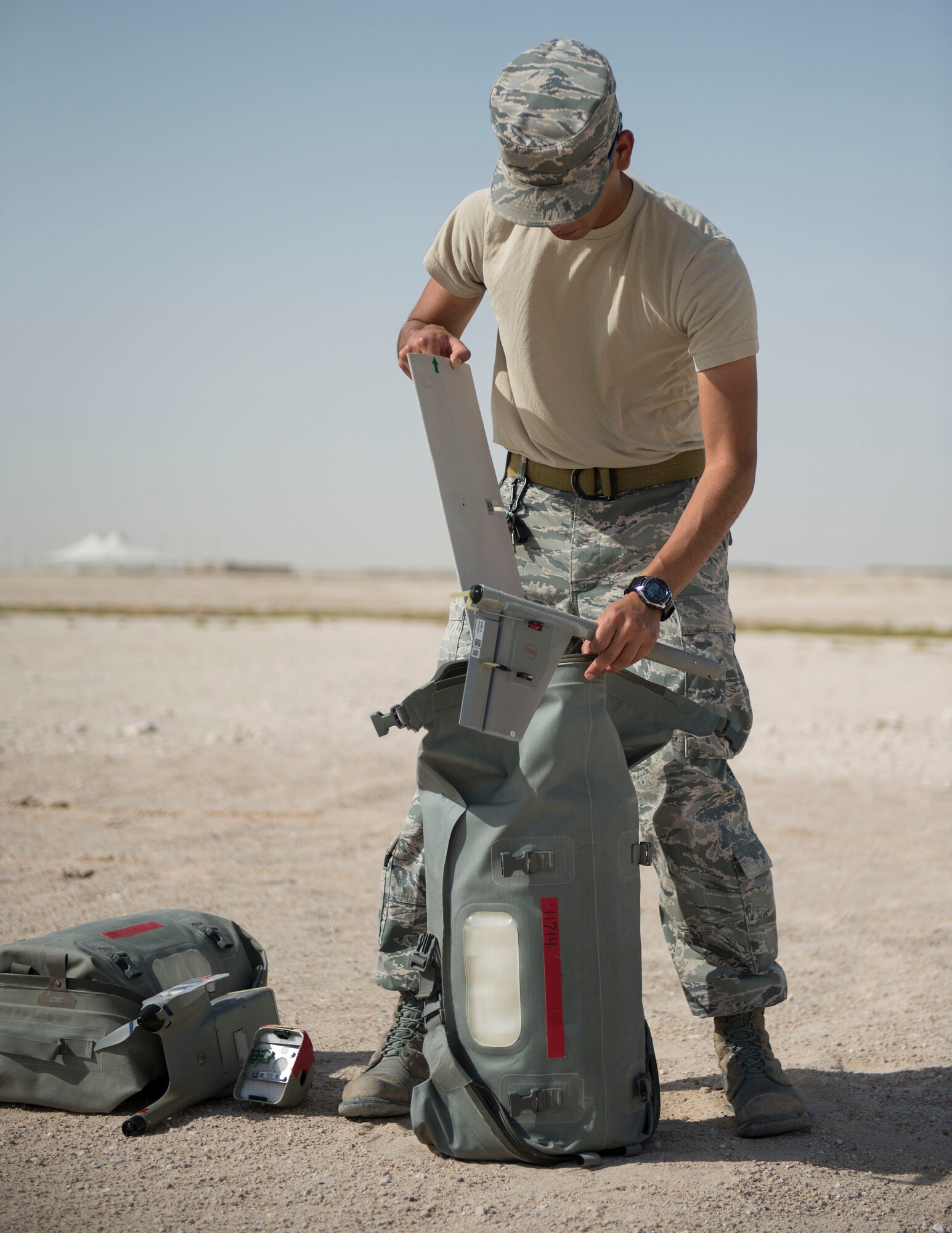 U.S. Air Force Senior Airman Luis Sandoval, a Raven- B operator with 379th Expeditionary Security Forces Squadron, pulls a wing for a RQ-11B Raven out of bag at Al Udeid Air Base, Qatar, July 3, 2017. The RQ-11 Raven is a small unmanned aircraft system which provides real-time imagery or video for the 379th ESFS. (U.S. Air Force photo by Tech. Sgt. Amy M. Lovgren)