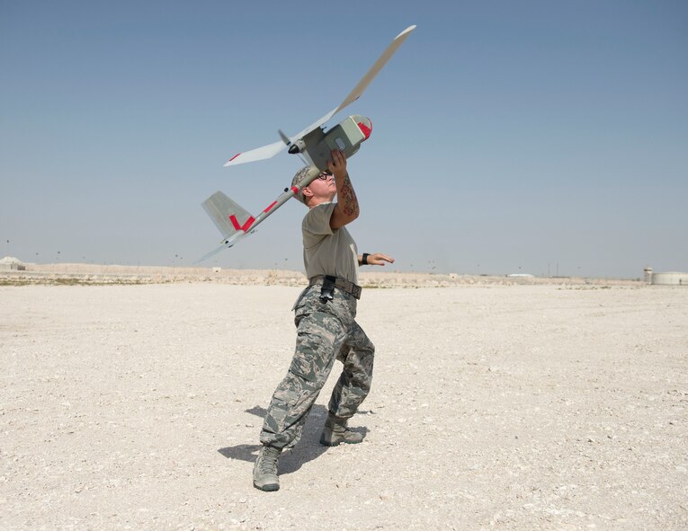 U.S. Air Force Staff Sgt. Helen Daniel, a Raven- B operator with 379th Expeditionary Security Forces Squadron, launches a RQ-11 Raven at Al Udeid Air Base, Qatar, July 3, 2017. The RQ-11 Raven is a small unmanned aircraft system which provides real-time imagery or video for the 379th ESFS. (U.S. Air Force photo by Tech. Sgt. Amy M. Lovgren)