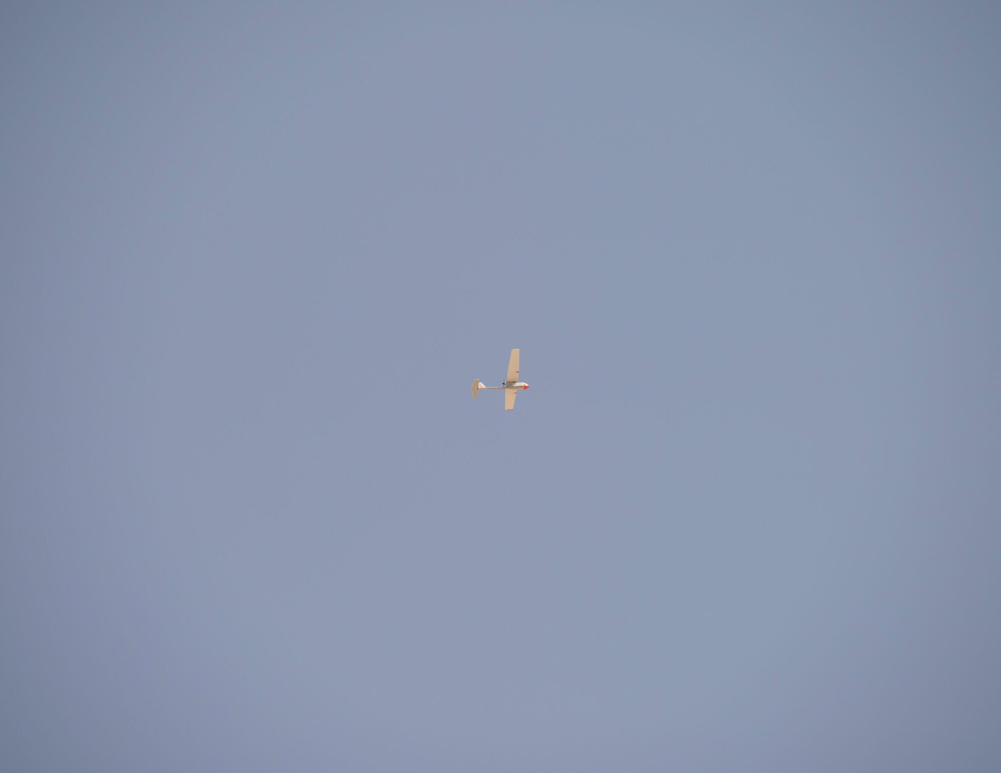 A RQ-11 Raven with the 379th Expeditionary Security Forces Squadron flies the skies at Al Udeid Air Base, Qatar, July 3, 2017. The RQ-11 Raven is a small unmanned aircraft system which provides real-time imagery or video for the 379th ESFS. (U.S. Air Force photo by Tech. Sgt. Amy M. Lovgren)