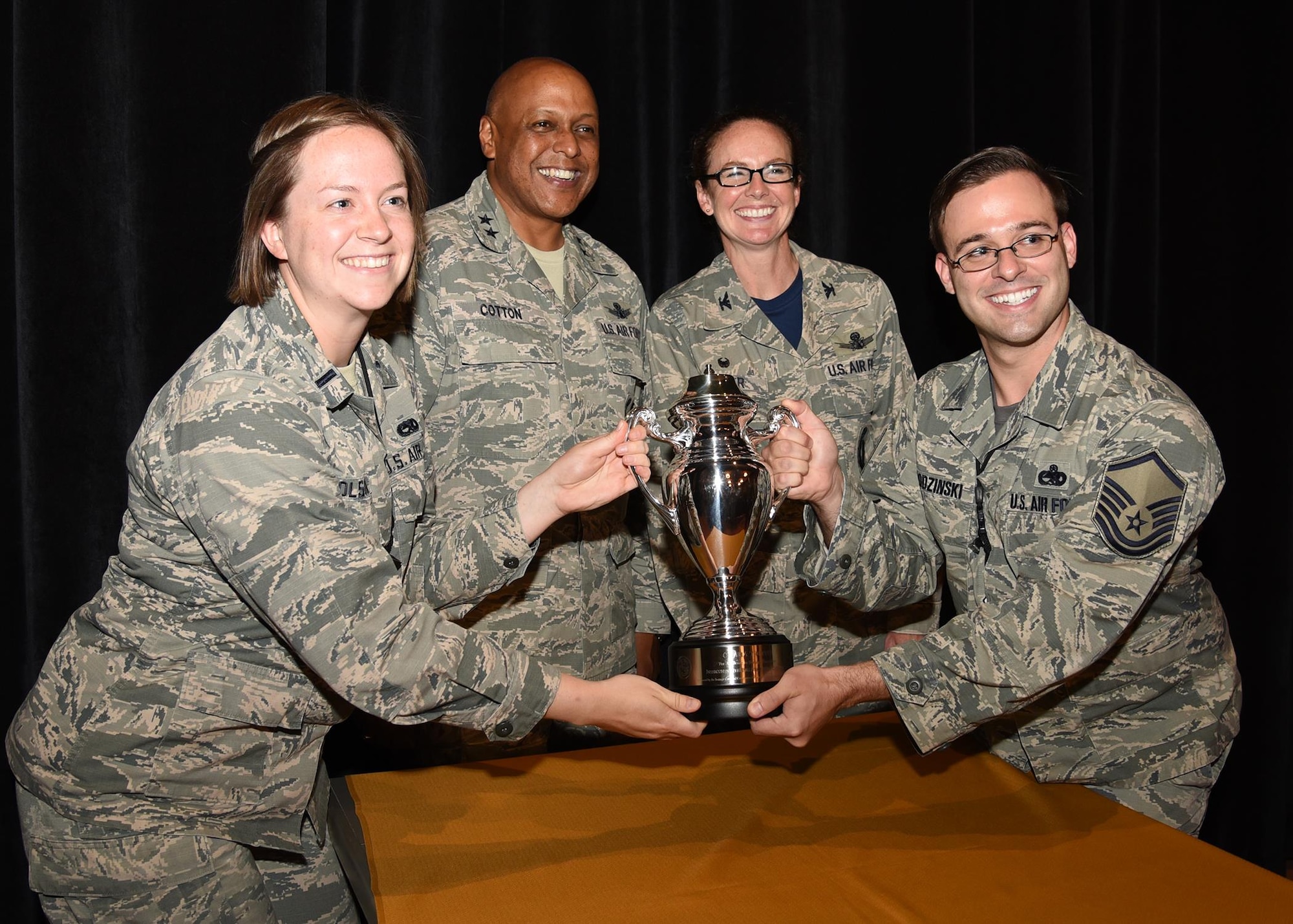 Members of the 90th Maintenance Group pose with the Omaha Trophy alongside Maj. Gen. Anthony Cotton, commander of 20th Air Force and Col. Stacy Huser, commander of the 90th Missile Wing after an all-call at the F. E. Warren Air Force Base, Wyo., theater July 21, 2017. The Omaha Trophy is awarded to the best missile wing in USSTRATCOM. (U.S. Air Force photo by Glenn S. Robertson)