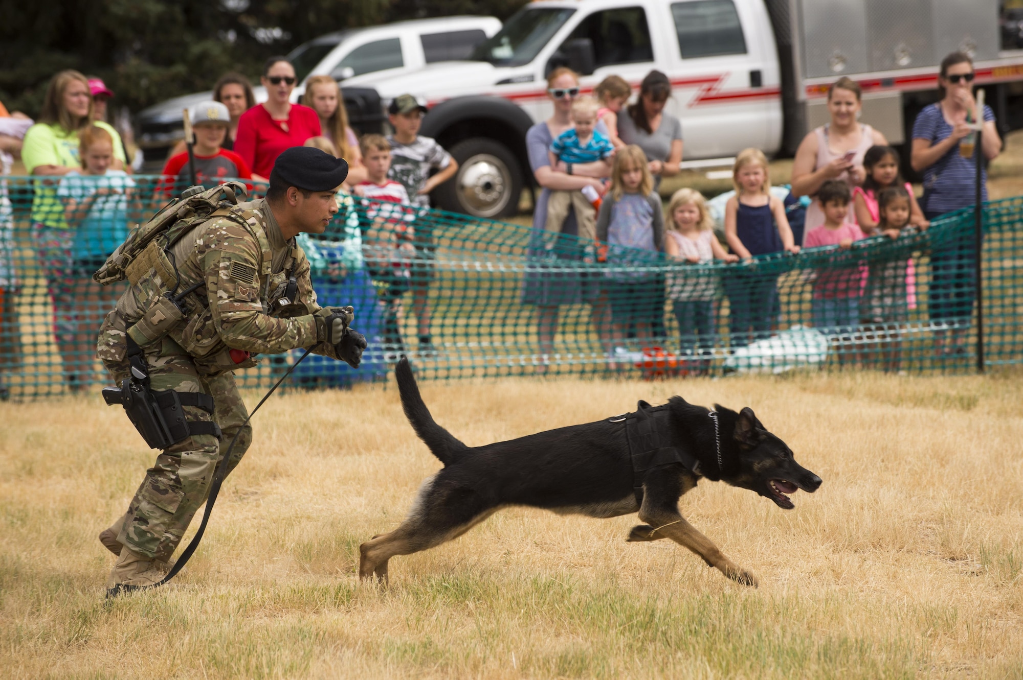 Adults and children look on as Staff Sgt. Desi Padilla, 90th Security Forces Squadron military working dog handler, releases Eby to catch a aggressor for a MWD demonstration during Fort D.A. Russell Days at F.E. Warren Air Force Base, Wyo., July 21, 2017. Dog handlers attend a 55 day training in order to be certified to work with the dogs on base. This year marks the 150th anniversary of F.E. Warren Air Force Base, and the annual base open house brings military and civilian communities together to learn more about the base’s rich history. (U.S. Air Force photo by Staff Sgt. Christopher Ruano)

