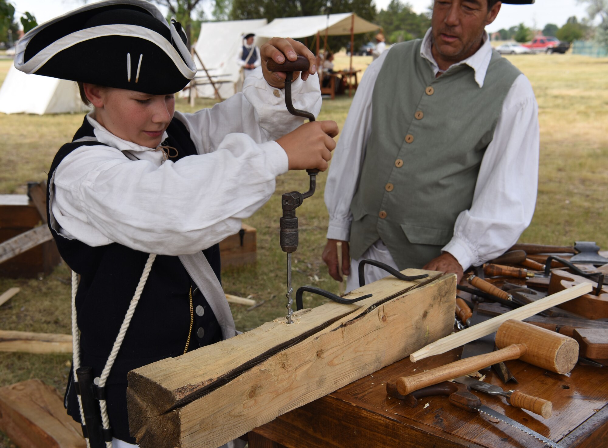 Theo Crandall drills a hole into a wood beam during Fort D.A. Russell Days at F.E. Warren Air Force Base, Wyo., July 21, 2017. He built the second set of legs for a workbench. This year marks the 150th anniversary of F.E. Warren Air Force Base, and the annual base open house brings military and civilian communities together to learn more about the base's rich history. (U.S. Air Force photo by Airman 1st Class Braydon Williams)