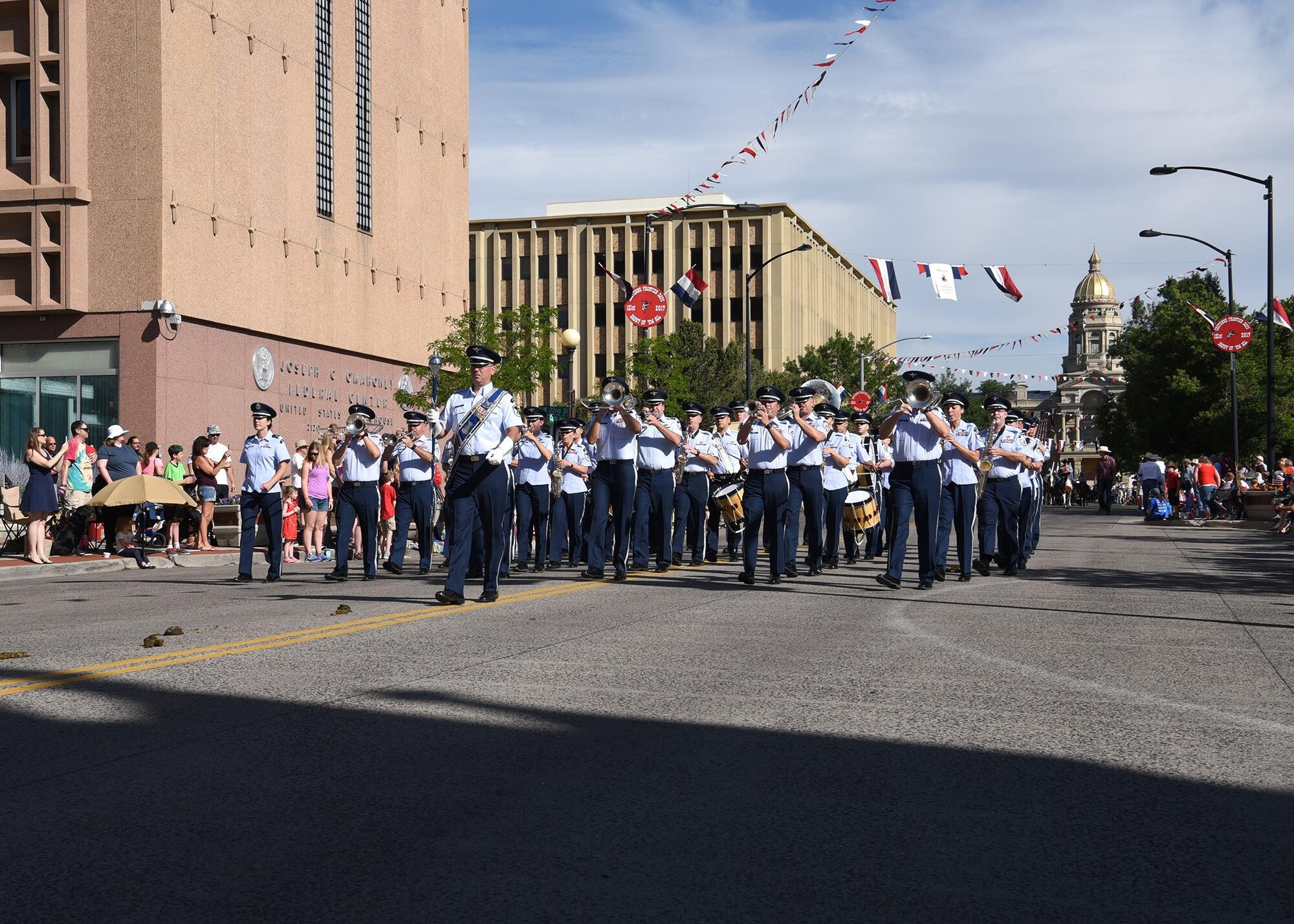 Members of the U.S. Air Force Academy Band play music as they march down the streets of Cheyenne, Wyo., during the 121st Cheyenne Frontier Days opening grand parade, July 22, 2017. Airmen play many roles in making CFD, the biggest event in Cheyenne, a success. This year marks the 150th anniversary of F.E. Warren Air Force Base and the city of Cheyenne. The two communities came together to celebrate during the 121st CFD rodeo and festival. (U.S. Air Force photo by Airman 1st Class Braydon Williams)