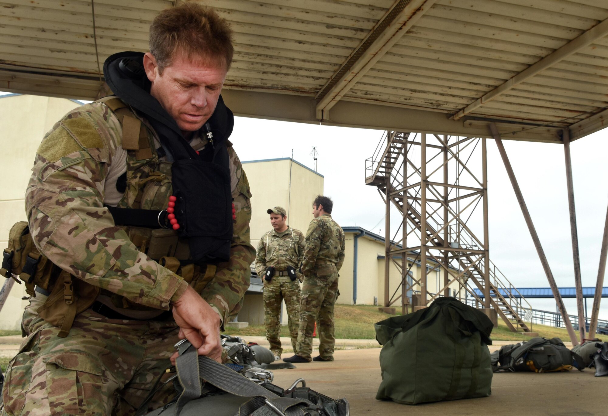 Senior Master Sgt. Andrew Hobbs, 181st Weather Flight superintendent, prepares to don his parachute equipment before a deliberate water drop into Lake Worth in Forth Worth, Texas, May 20, 2017. Hobbs is part of the Air Force Special Operations Weather Team, and as a member must undergo unique training to operate in hostile and denied territories to provide on-the-ground weather reporting. (Texas Air National Guard photo by Staff Sgt. Kristina Overton)