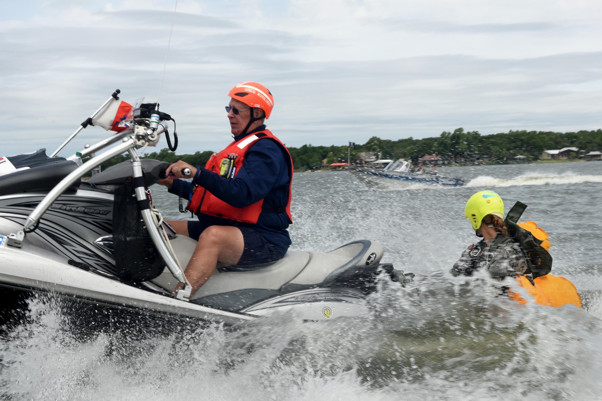 U.S. Army Specialist Whitley Tobei, 294th Quartermaster parachute rigger, rides to the shoreline with a member of the U.S. Coast Guard Auxiliary after parachuting into Lake Worth, Fort Worth, Texas, May 20, 2017. The training mission was scheduled for members to practice airborne covert water parachute infiltration. (Texas Air National Guard photo by Staff Sgt. Kristina Overton)