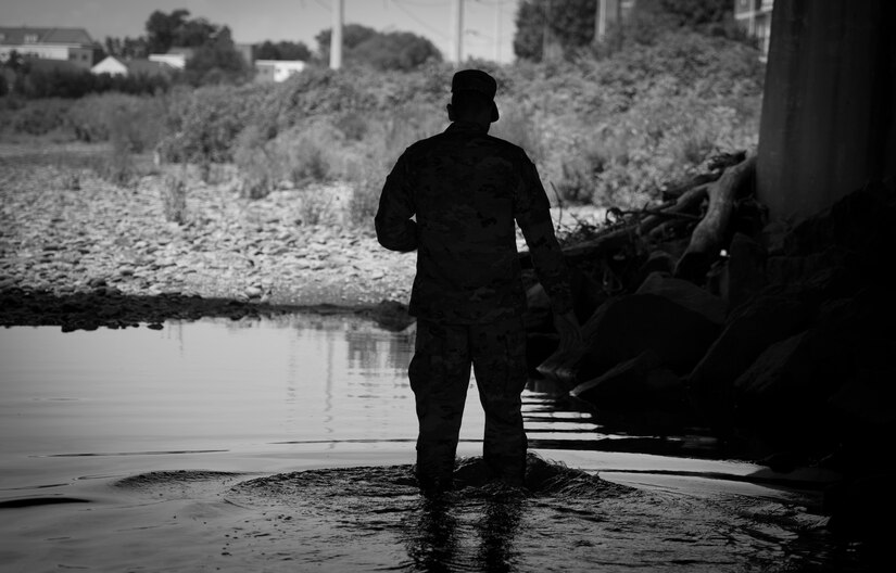 Capt. Doug Daspit, U.S. Army Reserve chaplain for the 321st Sustainment Brigade located in Baton Rouge, Louisiana, wades through the Four Mile Run creek for a photo shoot, after receiving the Chaplain of the Year award during the Reserve Officers Association National Convention in Crystal City, Virginia, July 22, 2017. Daspit was nominated for his response to recent Baton Rouge floods, providing one-on-one pastoral counseling to 38 Soldiers and their affected families. (U.S. Army Reserve photo by Sgt. Audrey Hayes)