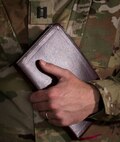 Capt. Doug Daspit, U.S. Army Reserve chaplain for the 321st Sustainment Brigade located in Baton Rouge, Louisiana, holds his bible shortly after receiving the Chaplain of the Year award during the Reserve Officers Association National Convention in Crystal City, Virginia, July 22, 2017. Daspit was nominated for his response to recent Baton Rouge floods, providing one-on-one pastoral counseling to 38 Soldiers and their affected families. (U.S. Army Reserve photo by Sgt. Audrey Hayes)