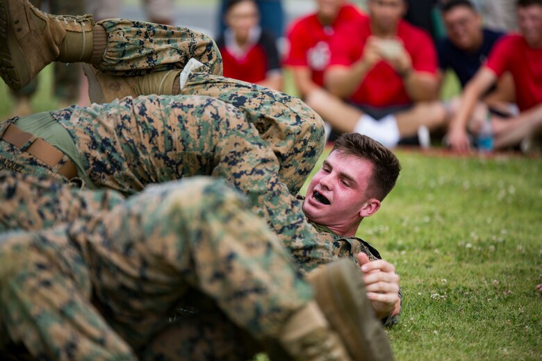 U.S. Marines with Marine Aviation Logistics Squadron (MALS) 12 grapple at Marine Corps Air Station Iwakuni, Japan, July 21, 2017. The USO hosted a field meet and cookout for MALS-12, which included several competitions such as grappling, pull-ups and a Humvee pull. (U.S. Marine Corps photo by Lance Cpl. Jacob A. Farbo)