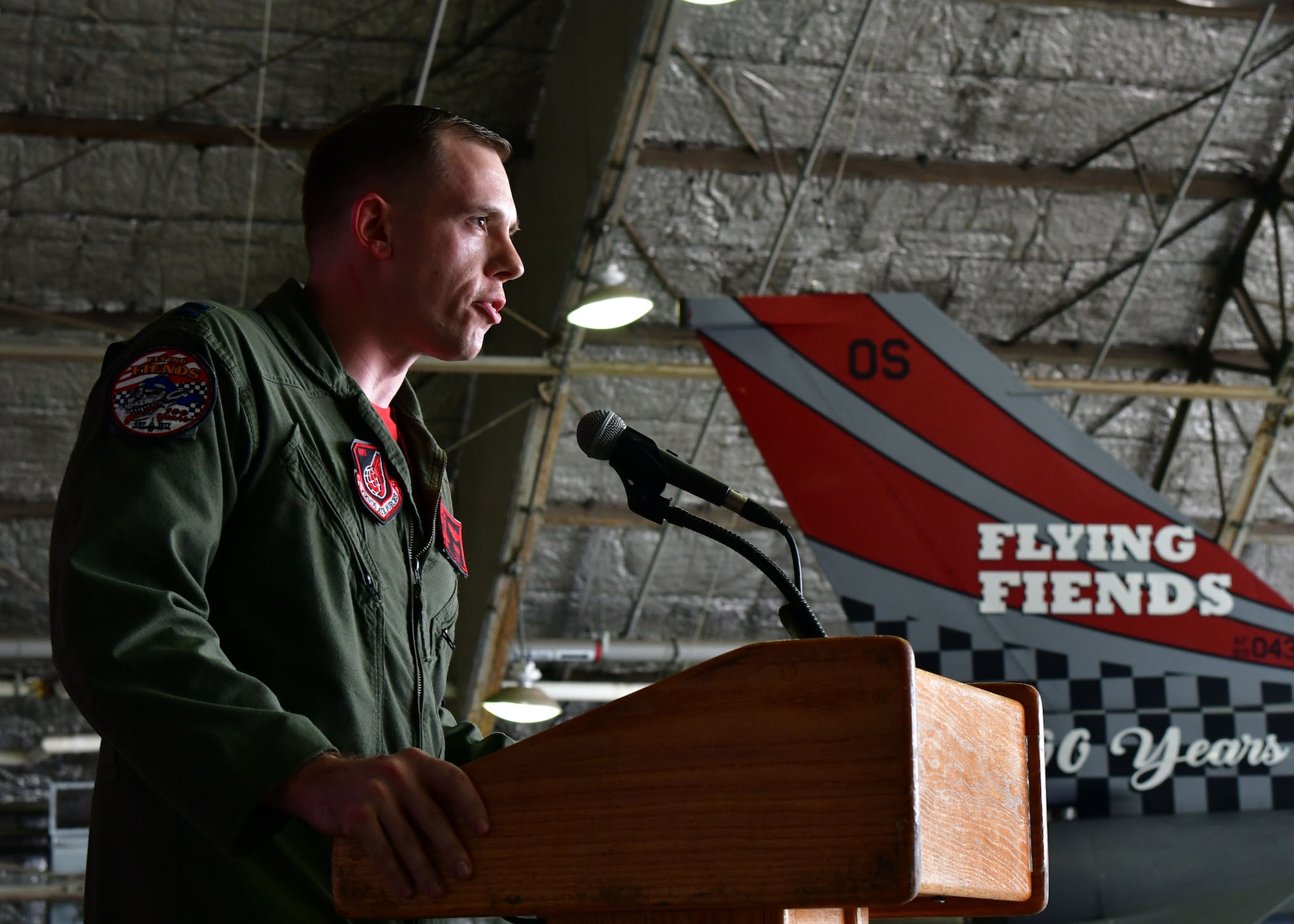 U.S. Air Force Capt. Wayne Mowery, 36th Fighter Squadron jet fighter pilot, speaks about the history of the 36th FS during a Tail Flash ceremony held July 21, 2017.Members from the 51st Maintenance Squadron Corrosion Control Shop painted the tail flash of an F-16 Fighting Falcon, which was unveiled during the ceremony in honor of the 36th FS’s 100 years of service to the U.S. Air Force. (U.S. Air Force photo by Senior Airman Franklin R. Ramos/Released)