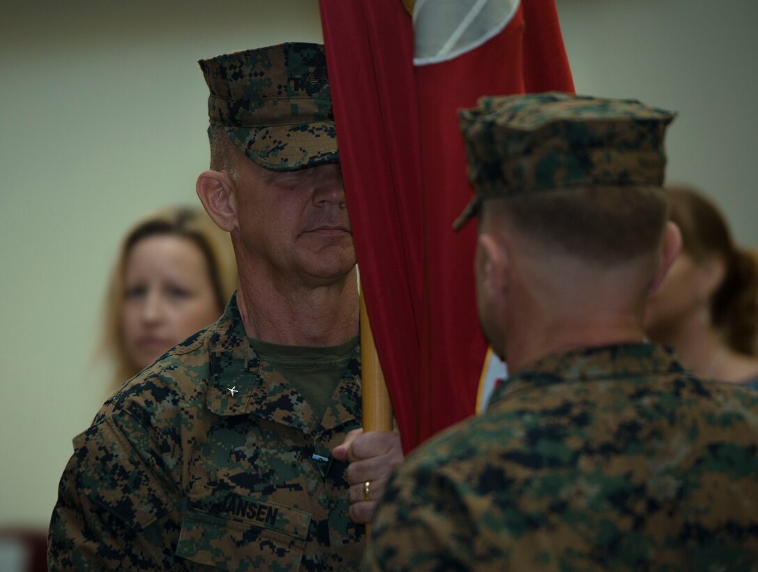 Brig. Gen. John M. Jansen passes the unit colors to Brig. Gen. Chris A. McPhillips during the 3rd Marine Expeditionary Brigade change of command ceremony at the theater on Camp Courtney, Okinawa, Japan, July 21, 2017. The ceremony symbolizes the exchange of responsibility to the new commanding general. McPhillips, the former 1st Marine Aircraft Wing assistant commander in Okinawa, Japan, assumed responsibility as the new commanding general of 3rd MEB. (U.S. Marine Corps photo by Lance Cpl. Andrew Neumann)