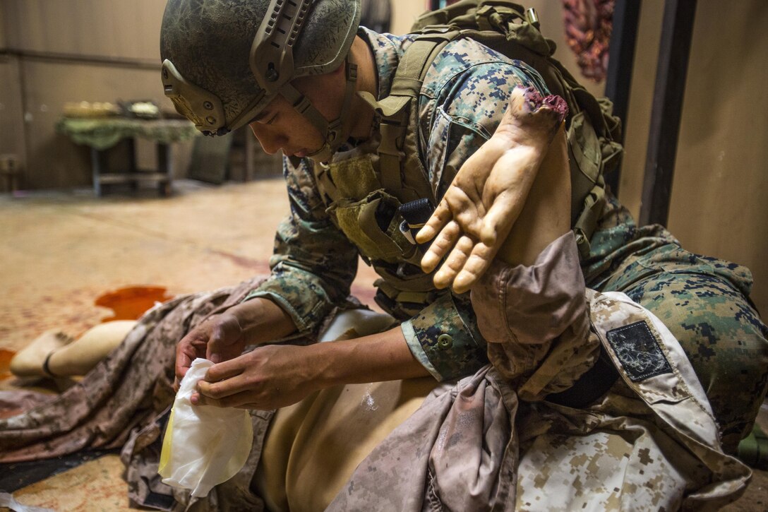 Sgt. Gene J. Koo, with 3rd Reconnaissance Battalion, 3rd Marine Division, III Marine Expeditionary Force, applies a chest seal to a simulated casualty during the Tactical Combat Casualty Care course at the Tactical Medical Simulation Center, Camp Hansen, Okinawa, Japan, July 13, 2017. The course included hands-on medical training and, on the final day, a realistic scenario designed for the trainee to react under pressure. Koo is from Houston, Texas. (U.S. Marine Corps photo by Lance Cpl. Andy Martinez)