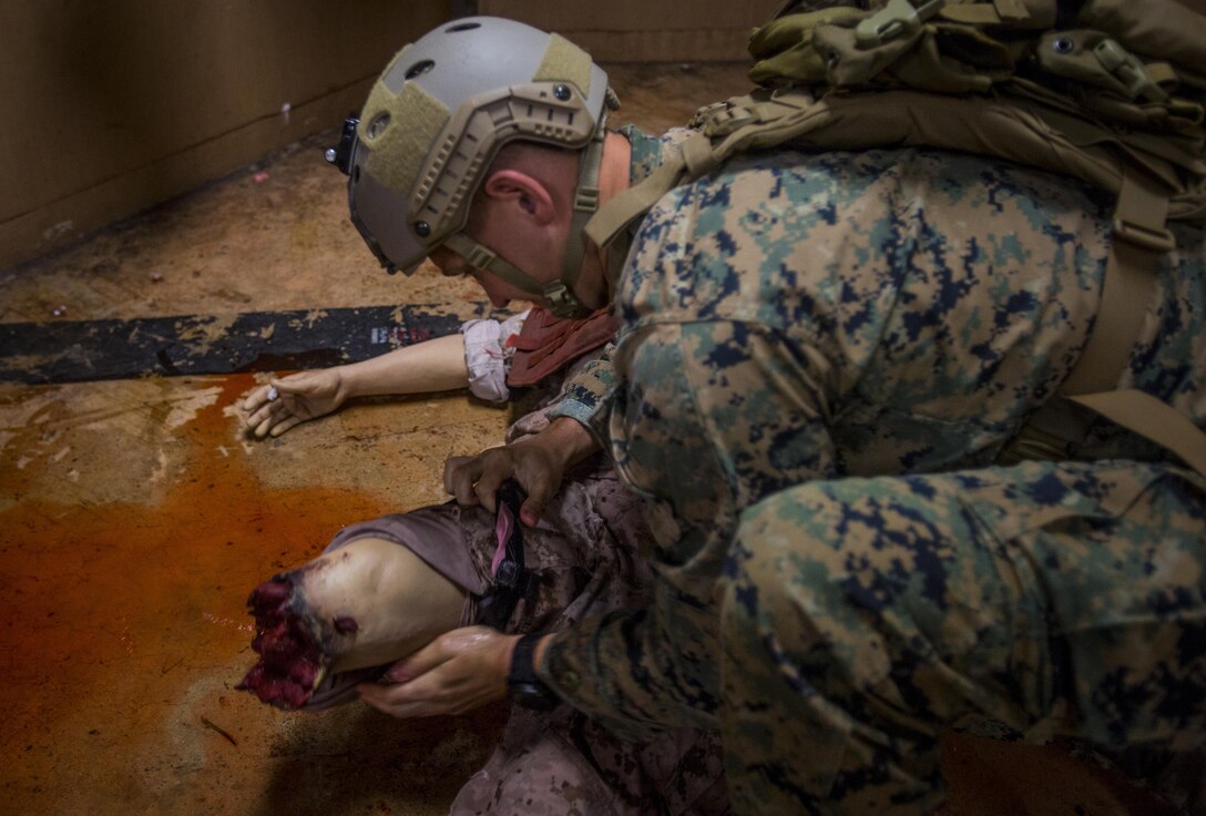 A Marine with 3rd Reconnaissance Battalion, 3rd Marine Division, III Marine Expeditionary Force applies a tourniquet to a simulated casualty during the Tactical Combat Casualty Care course at the Tactical Medical Simulation Center, Camp Hansen, Okinawa, Japan, July 13, 2017. The Marines completed a practical application portion of the course, which consisted of applying medical care in a combat environment. (U.S. Marine Corps photo by Lance Cpl. Andy Martinez)