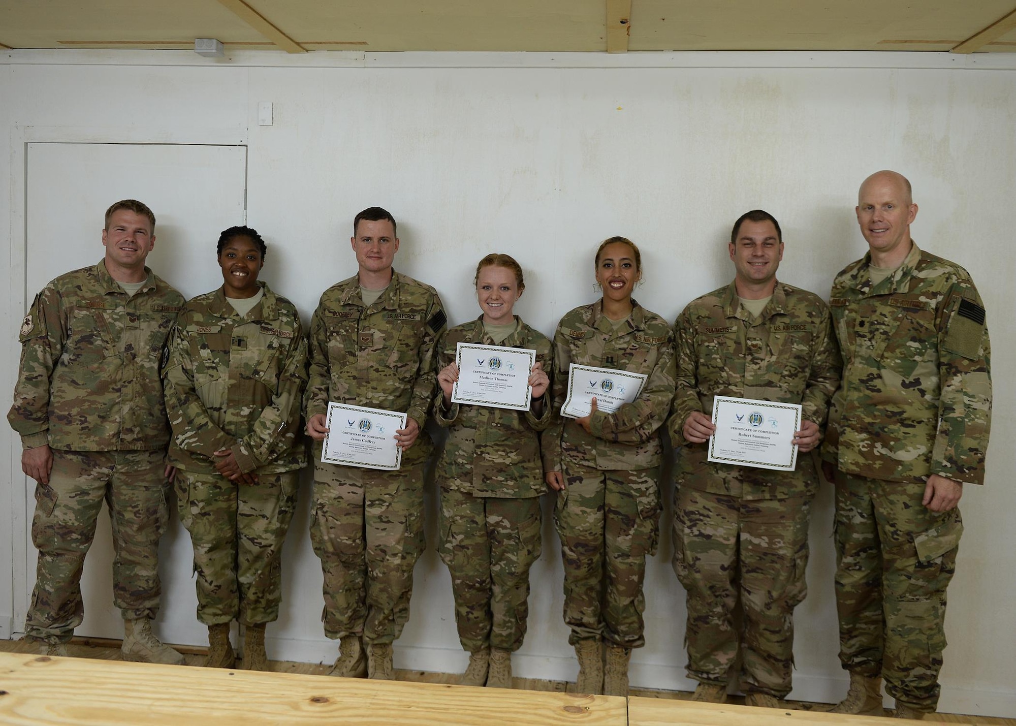 Deployed Airmen show off their training certificates with their unit leadership after completing a 40 hour Sexual Assault Prevention and Response Victim Advocate Training Program at an undisclosed location, East Africa, July 14, 2017. Victim advocates are the representation of the SAPR program for the Sexual Assault Response Coordinator and are liaisons between victims and the SARC. (U.S. Air Force photo by Senior Airman Jimmie D. Pike)