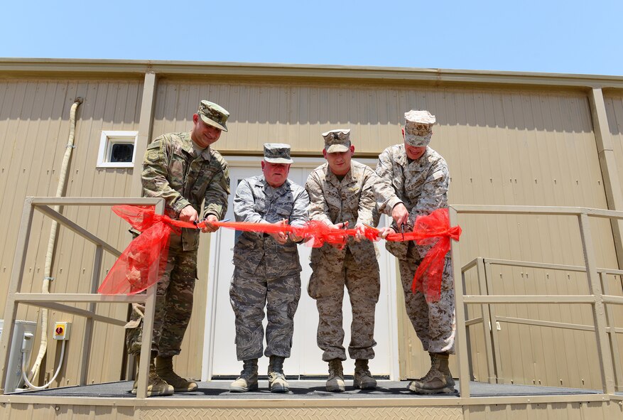 U.S. Air Force Col. John Gonzales (left), 407th Air Expeditionary Group commander, Col. Ronald Crandall (middle-left), Lt. Cmdr. David Klimasky (middle-right), and Col. William Vivian (right), Special Purpose Marine Air Ground Task Force commander, cut the ribbon during the opening of the new integrated medical facility at the 407th AEG July 22, 2017 in Southwest Asia. The new clinic will house U.S. Air Force, U.S. Navy, U.S. Marine Corps, and coalition medical professionals who provide excellent, personalized medical care that enables our forces to generate, execute and sustain combat airpower. (U.S. Air Force photo by Tech. Sgt. Andy M. Kin)