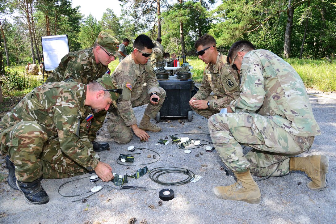 U.S. paratroopers and Slovenian soldiers prepare a C4 explosive charge to be used in breach training during a live-fire demolition as part of Exercise Rock Knight at Pocek Range in Postonja, Slovenia, July 20, 2017. Army photo by Paolo Bovo