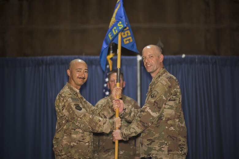Col. Christopher K. Fuller, 332nd Expeditionary Mission Support Group commander, left, passes the guidon to Lt. Col. Kenneth L. Knutson, during the 332nd Expeditionary Communications Squadron change of command ceremony July 22, 2017, in Southwest Asia. The passing of a guidon symbolizes a unit’s transfer of command. (U.S. Air Force photo/Senior Airman Damon Kasberg)
