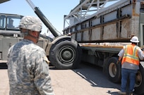 Sgt. Michael Tovar of the 250th Transportation Company out of El Monte, Calif., observes as section a Modular Causeway System (MCS) are loaded onto his M915 truck at the Marine Corps Logistics Base in Yermo, Calif., during Big LOTS West 17.