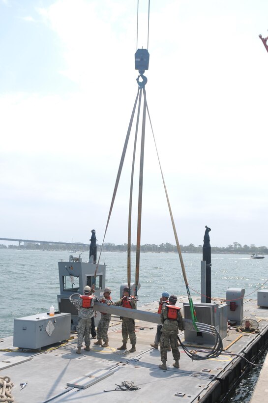 Soldiers of the 331st Transportation Company (Causeway) assemble the beam portion of a Modular Warping Tug (MWT) at the Port of San Diego in preparation to construct a Modular Causeway System (MCS) during Big LOTS West 17.