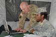 Cpt. Jeffrey Olsen, 650th RSG, Reception Staging Onward-Movement Integration commander at Forwarding Operating Base Coronado look over RSOI station responsibilities with Spc. Ondra Caruthers, 650th RSG, FOB Coronado, Calif., July 15, 2017, during Big LOTS West 2017 exercise. The RSOI station is an important function of a military exercise in that it provides accountability and integration of personnel to the mission. The 650th RSG ran the RSOI for Big LOTS West 2017 from 6 July through 16 July.