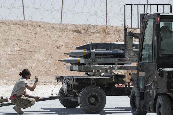 Staff Sgt. Carissa Fall, 332nd Expeditionary Maintenance Squadron precision guided munitions crew chief, guides an Airman as he loads missiles on a trailer July 7, 2017, in Southwest Asia. The squadron builds and maintains a variety of munitions to support F-15E Strike Eagles and MQ-9 Reapers. (U.S. Air Force photo/Senior Airman Damon Kasberg)