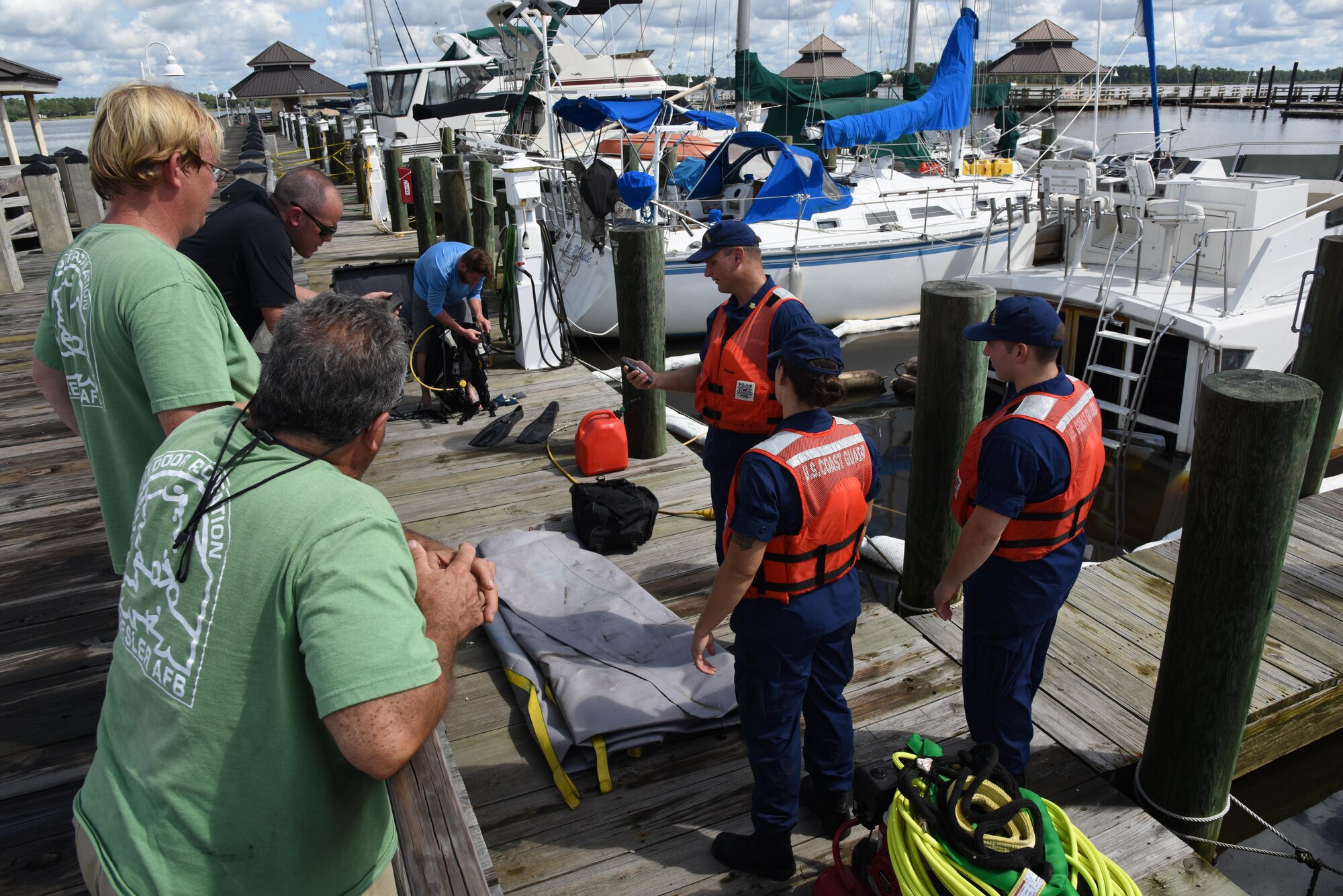 Members of Keesler Outdoor Recreation, Coast Guard Mobile Sector Incident Management Division, Mobile Al., and Tow-Boat U.S. Biloxi help retrieve sunken  privately-owned boat at the marina July 19, 2017, on Keesler Air Force Base, Miss. The agencies gathered to ensure appropriate guidelines and safety procedures were followed prior to retrieving the boat. (U.S. Air Force photo by Kemberly Groue)

