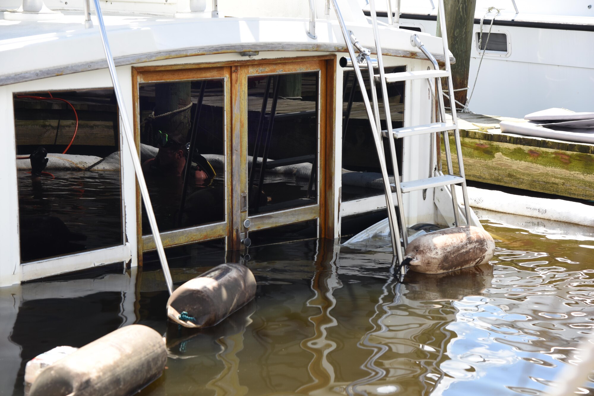A privately-owned boat sinks to the bottom of the marina while docked July 19, 2017, on Keesler Air Force Base, Miss. Several agencies, including members of Keesler Outdoor Recreation, Coast Guard Mobile Sector Incident Management Division, Mobile, Al. and Tow-Boat U.S. Biloxi, gathered to ensure appropriate guidelines and safety procedures were followed prior to retrieving the boat. (U.S. Air Force photo by Kemberly Groue)