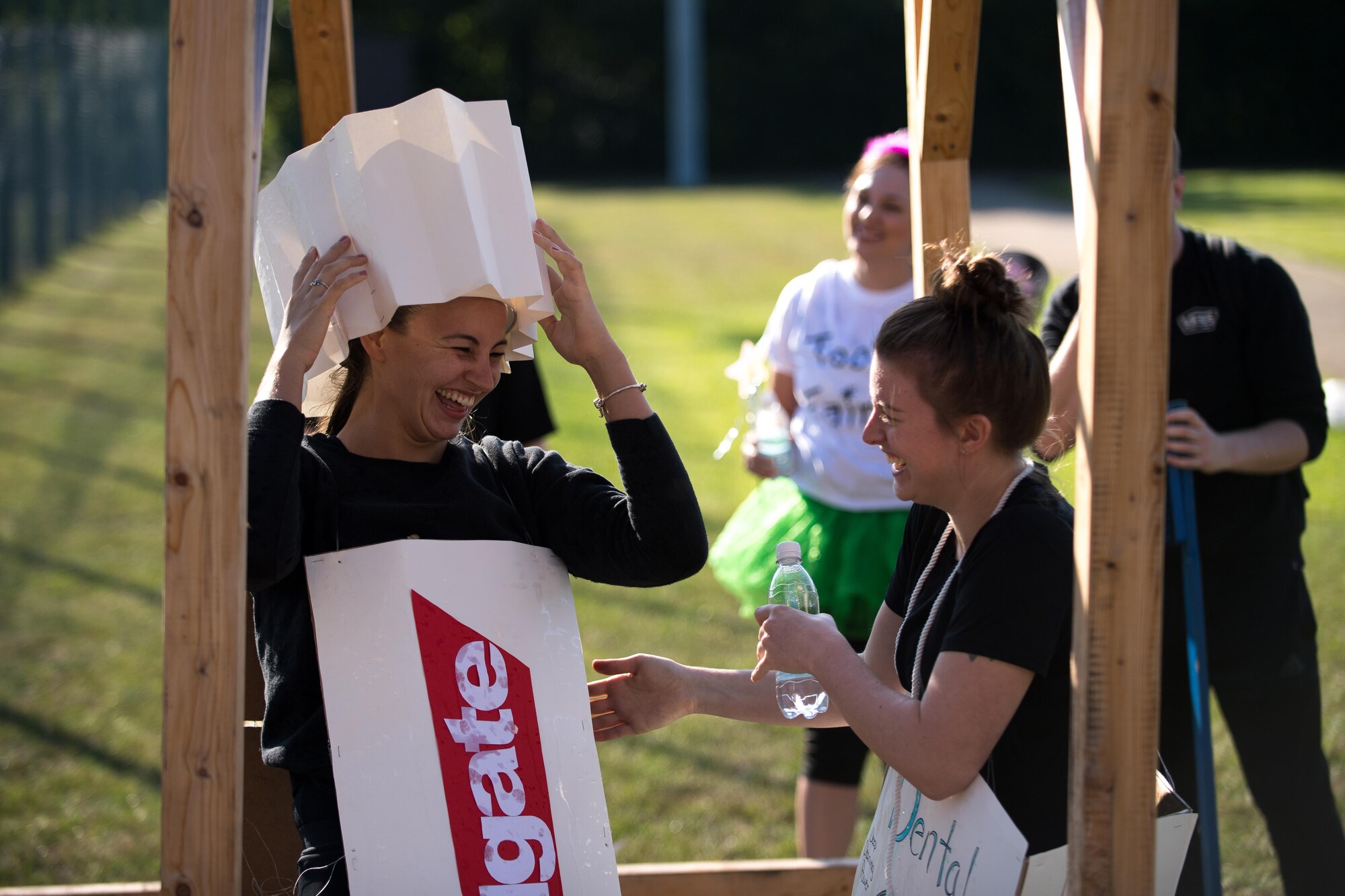 U.S. Air Force Staff Sgt. Jordan Hebner and U.S. Air Force Senior Airman Jessica Slatt, both 86th Dental Squadron dental assistants, share a laugh after falling off a set of monkey bars during the annual Mudless Mudder on Ramstein Air Base, Germany, July 21, 2017. Slatt came to Hebner’s aid to assist her off the obstacle. The Mudless Mudder was the 86 Airlift Wing’s resilience day event, promoting camaraderie amongst Airmen. (U.S. Air Force photo by Senior Airman Devin Boyer)