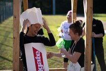 U.S. Air Force Staff Sgt. Jordan Hebner and U.S. Air Force Senior Airman Jessica Slatt, both 86th Dental Squadron dental assistants, share a laugh after falling off a set of monkey bars during the annual Mudless Mudder on Ramstein Air Base, Germany, July 21, 2017. Slatt came to Hebner’s aid to assist her off the obstacle. The Mudless Mudder was the 86 Airlift Wing’s resilience day event, promoting camaraderie amongst Airmen. (U.S. Air Force photo by Senior Airman Devin Boyer)