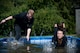 U.S. Air Force Senior Airman Michael Krawczyk and U.S. Air Force Staff Sgt. Jordan Hebner, both 86th Dental Squadron dental assistants, leap into a pool during the annual Mudless Mudder on Ramstein Air Base, Germany, July 21, 2017. If teams could not clear an obstacle, they were required to perform ten burpees to continue the race. (U.S. Air Force photo by Senior Airman Devin Boyer)