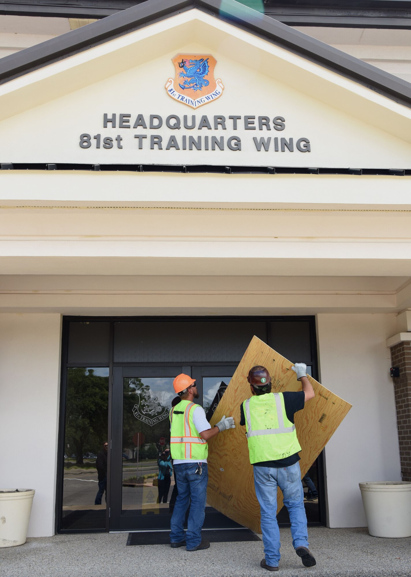 Jeremy Railey and Colton Freeman, Base Operations Support carpenters, board the front doors of the 81st Training Wing headquarters building during a hurricane exercise July 18, 2017, on Keesler Air Force Base, Miss. The purpose of the exercise was to prepare Keesler for the current hurricane season. (U.S. Air Force photo by Kemberly Groue)