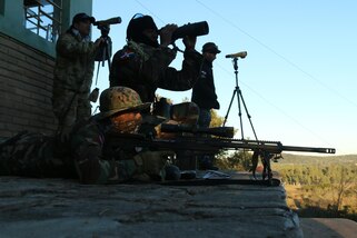 A Dominican competitor scans the range for targets over his sniper rifle July 19, 2017 during Fuerzas Comando in Paraguari, Paraguay. The field shoot event required a two-man rifle team to hit 10 long-range targets. The competition is about helping competing countries learn new tactics to foster regional security. (U.S. Army photo by Spc. Elizabeth Williams/Released)