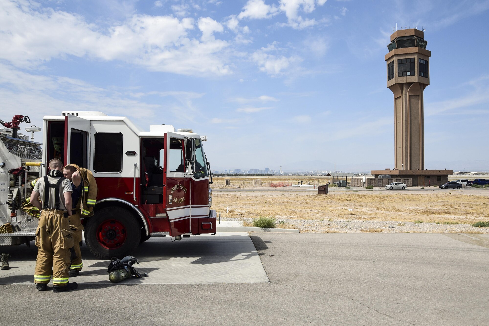 Firefighters assigned to the 99th Civil Engineer Squadron prepare their gear outside the air traffic control tower at Nellis Air Force Base, Nev., July 18, 2017. One of the team’s training exercises is to climb the air traffic control tower’s 10 stories to practice their readiness and emergency response capabilities. (U.S. Air Force photo by Airman 1st Class Andrew D. Sarver/Released)