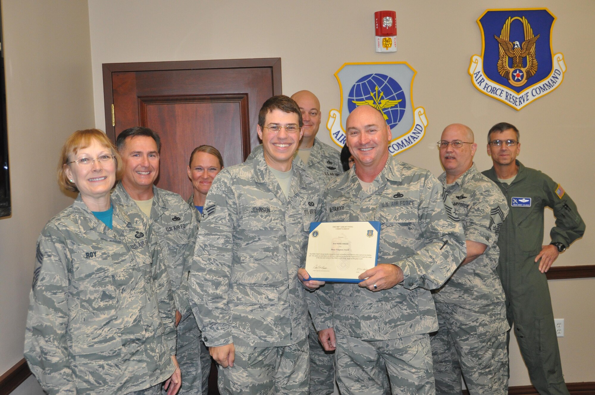 Senior Airman Nicholas Johnson, emergency actions controller at the Maxwell Command Post receives the Sharp Wingman award from his nominator, Chief Master Sgt. Leon Alexander, superintendent of the 908th Aircraft Maintenance Squadron. The award is presented quarterly by the 908th Chiefs Group, led by 908th Airlift Wing Command Chief Master Sgt. Tina Carlson, to Airmen who go above and beyond to accomplish the mission. (U.S. Air Force photo by Bradley J. Clark)