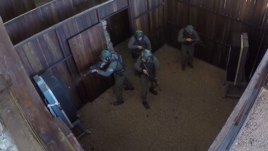 Argentine competitors fire at targets and stand guard for their teammates in the combined assault event July 22, 2017, during Fuerzas Commando in Cerrito, Paraguay. In the event, teams charge through a shoot house and clear all rooms, before they rescue a simulated hostage. (U.S. Army photo illustration by Pfc. Lauren Sam/Released) (This image was created by capturing a still frame from a video.)