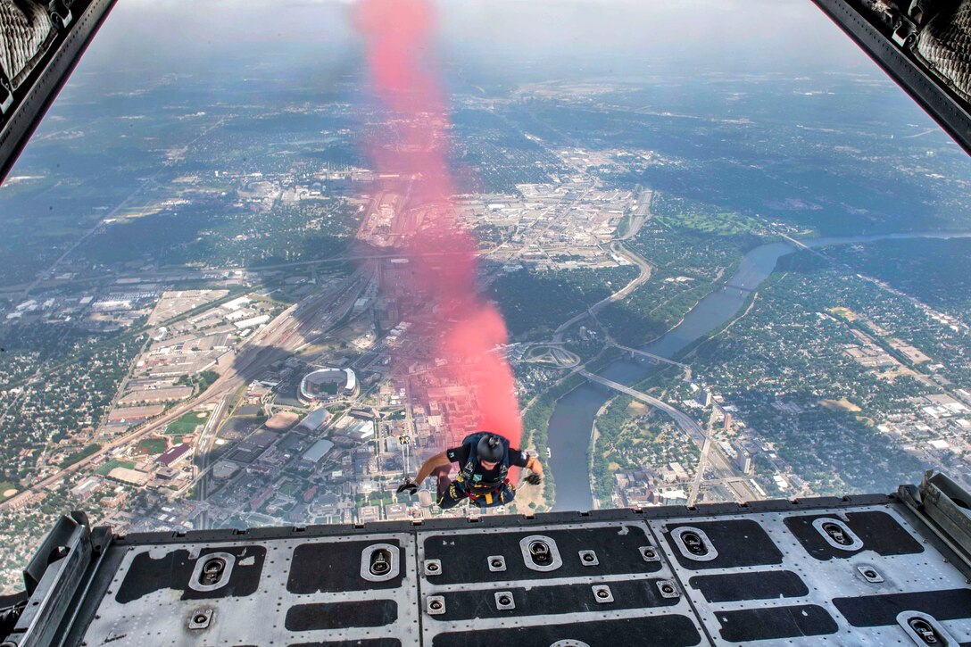 Retired Navy SEAL Jim Woods, a member of U.S. Navy Parachute Team “The Leap Frogs,” trails smoke as he jumps from a C-130 Hercules aircraft during a skydiving demonstration at the Summer X Games in Minneapolis, July 15, 2017. Peterson is a Special Warfare operator. Navy photo by Petty Officer 3rd Class Kelsey L. Adams