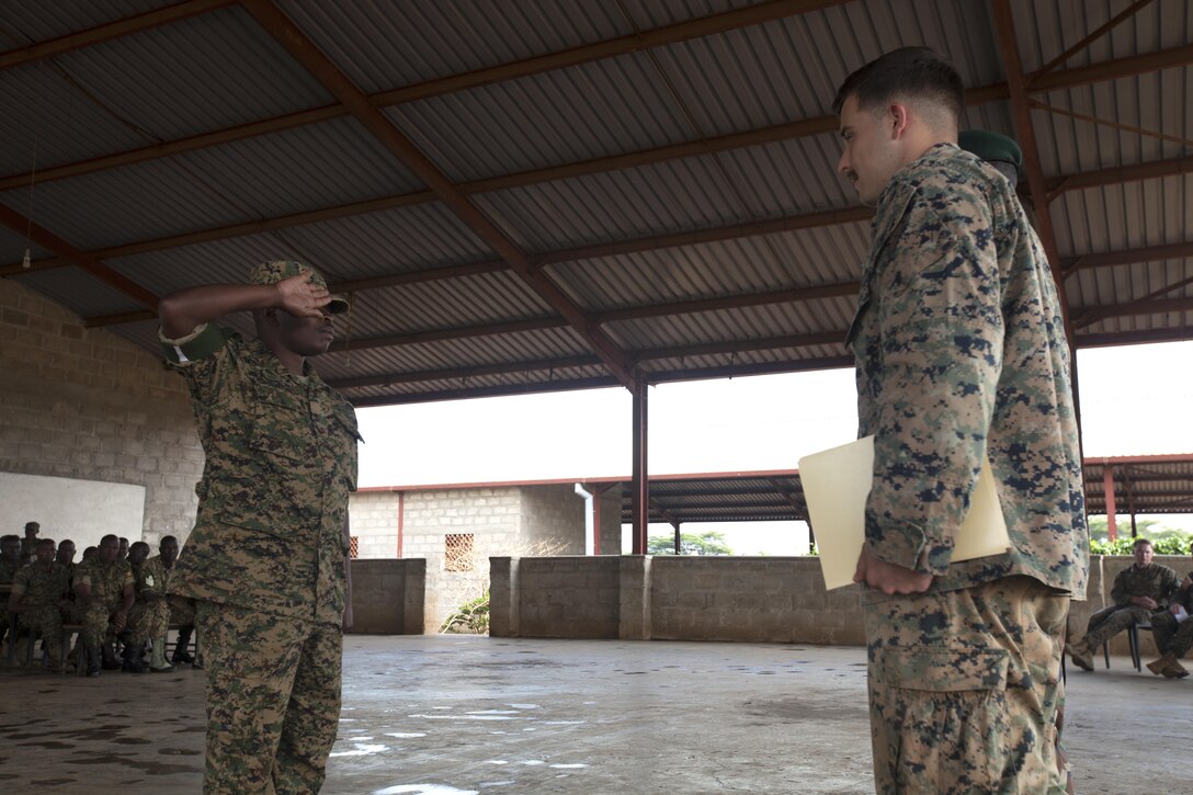 A member of the Uganda People’s Defence Force salutes a U.S. Marine assigned to Special Purpose Marine Air-Ground Task Force-Crisis Response-Africa logistics combat element during a logistics training graduation at Camp Singo, Uganda, July 6, 2017. Camp Singo training included practical application and a final exercise, which focused on tactical scenario training to prepare the UPDF for future African Union Missions in Somalia deployments. (U.S. Marine Corps photo by 1st Lt. Alexandra R. Bello)