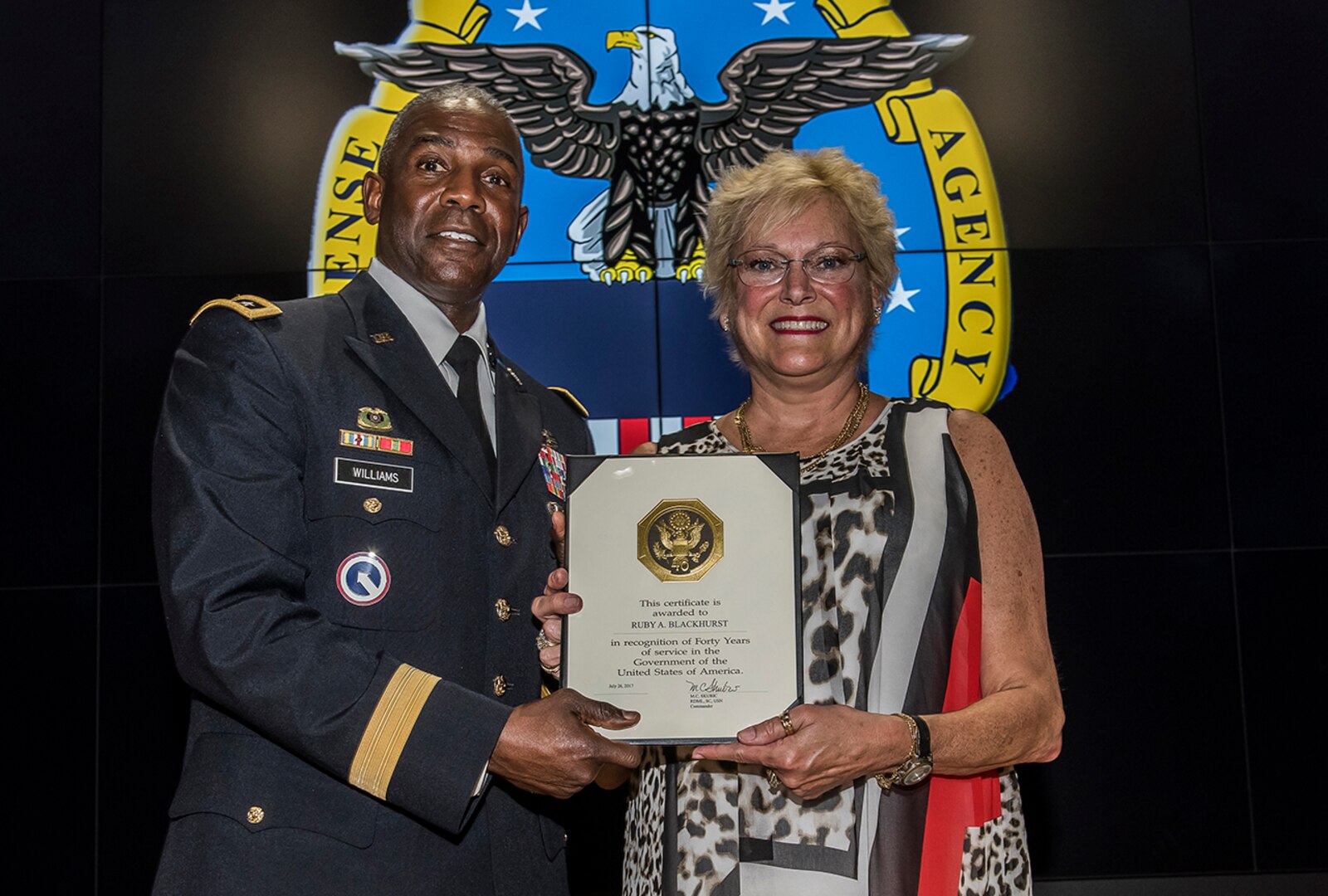 Defense Logistics Agency Director Army Lt. Gen. Darrell Williams presents a Service Award to Ruby Blackhurst to recognize her 40-year career with the agency. Blackhurst is a procurement specialist in the Strategic Acquisitions Programs Directorate at DLA Land and Maritime in Columbus, Ohio. Williams was at Defense Supply Center Columbus July 20 during his first Town Hall at the installation since becoming director of the agency.