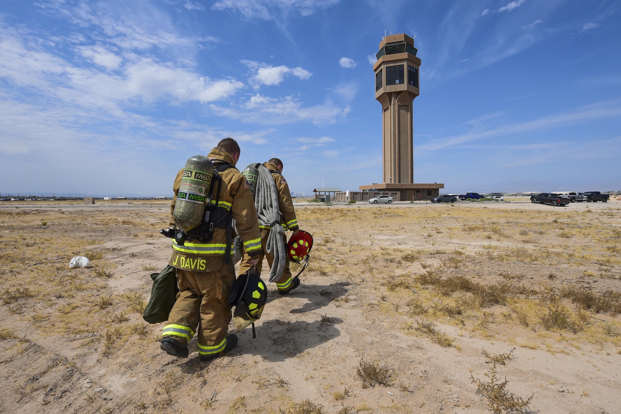 Senior Airman Jordan Davis, 99th Civil Engineer Squadron engine operator, and Staff Sgt. Blaine Erway, 99th CES firefighter crew chief, walk to the air traffic control tower at Nellis Air Force Base, Nev., July 18, 2017. The team climbed the 10 stories to simulate responding to a medical or electrical fire emergency at the top of the tower.