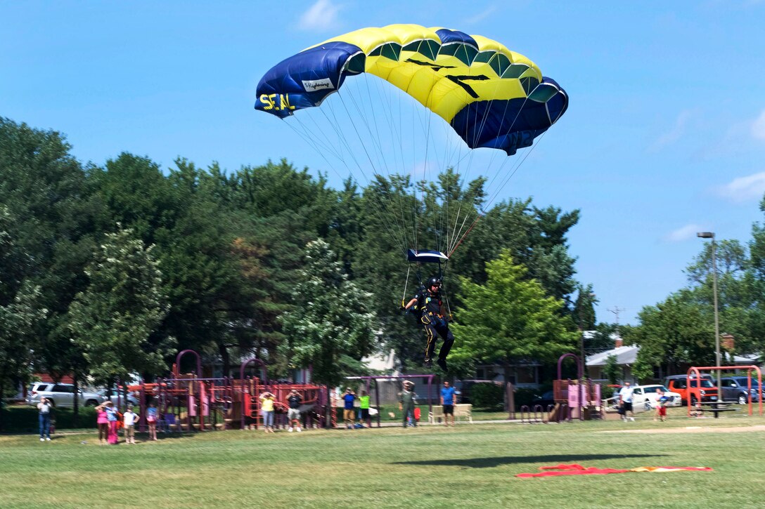 Retired Navy SEAL Jim Woods, a member of U.S. Navy Parachute Team “The Leap Frogs,” prepares to land during an aerial demonstration above Hazel Park Recreation Center as part of Navy Week in Minneapolis, July 17, 2017. Navy photo by Petty Officer 2nd Class Lenny LaCrosse