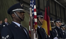 U.S. Air Force Airman 1st Class Pascal Nyowatchon, 1st Air and Space Communications Operations Squadron client systems technician, holds a rifle while posting the colors with his fellow honor guardsmen during a change of command ceremony on Ramstein Air Base, Germany, July 20, 2017. The Ramstein Base Honor Guard also participates in ceremonies such as funerals, retirements, promotions, and graduations. (U.S. Air Force photo by Senior Airman Tryphena Mayhugh)