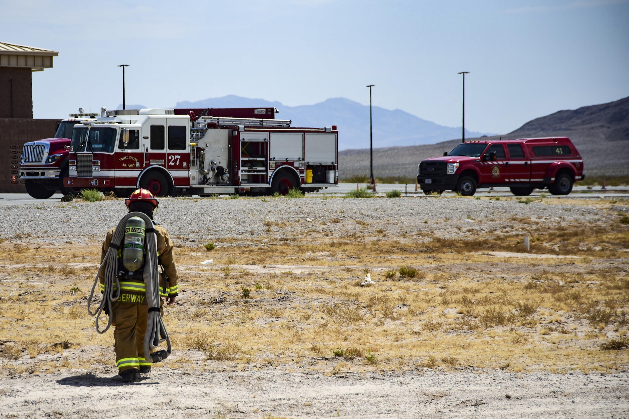 Staff Sgt. Blaine Erway, 99th Civil Engineer Squadron firefighter crew chief, walks back to fire engine 27 at Nellis Air Force Base, Nev., July 18, 2017. Erway and his team just completed climbing 10 stories to the top of the air traffic control tower for an emergency response readiness training exercise. (U.S. Air Force photo by Airman 1st Class Andrew D. Sarver/Released)