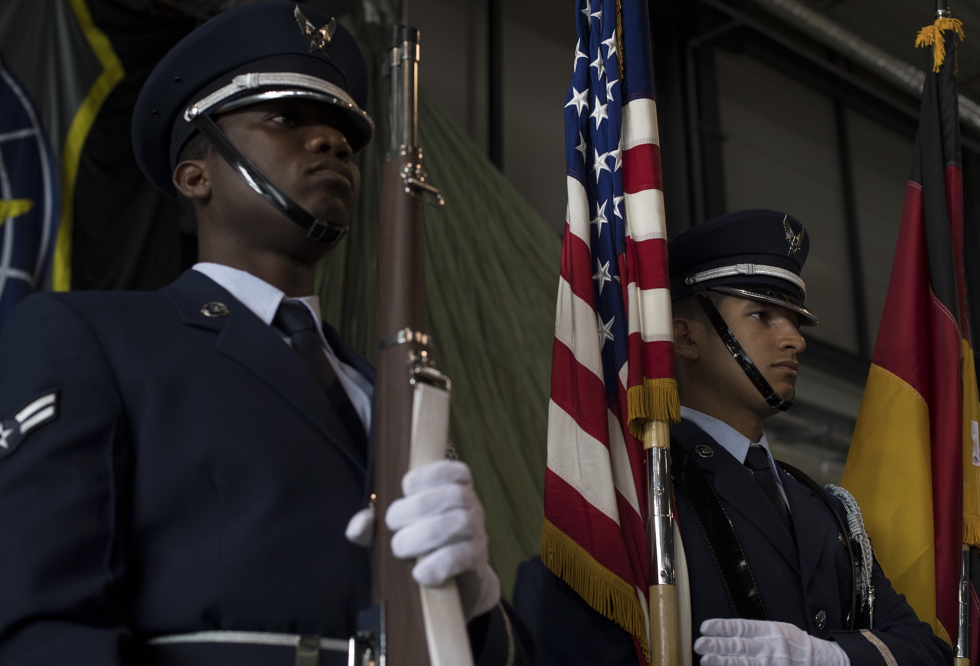 U.S. Air Force Airman 1st Class Pascal Nyowatchon, Ramstein Base Honor Guardsman and 1st Air and Space Communications Operations Squadron client systems technician (left), and U.S. Air Force Senior Airman Eric Feliciano, Ramstein Base Honor Guardsman and 721st Aerial Port Squadron fleet services specialist, post the colors during a change of command ceremony on Ramstein Air Base, Germany, July 20, 2017. The Ramstein Base Honor Guard meets every Tuesday and Thursday from 4-6 p.m. to practice their movements for details. (U.S. Air Force photo by Senior Airman Tryphena Mayhugh)