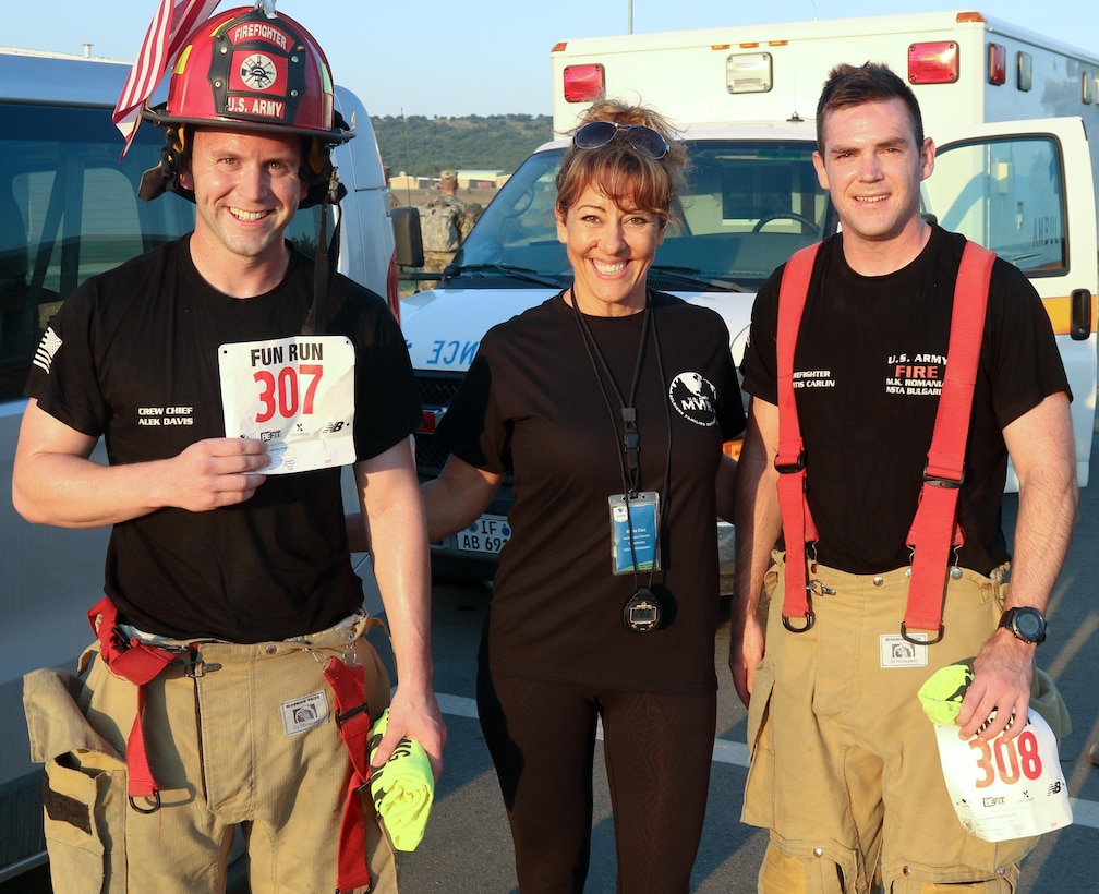 Sgt. Alek Davis (left) and Sgt. Curtis Carlin (right) of the 487th Engineering Detachment (Firefighters), US Army Reserve, Fort Des Moines, Iowa, pause for a photograph with race organizer Maria Diaz (center), Fitness Coordinator, US Army Morale Welfare and Recreation (MWR) at Novo Selo Training Area (NSTA), Bulgaria, on July 21, 2017. The Soldiers completed a 5K race on NSTA in full “turn-out” gear in part to honor fallen firefighters.  (US Army photo by Master Sgt. JD Phippen)