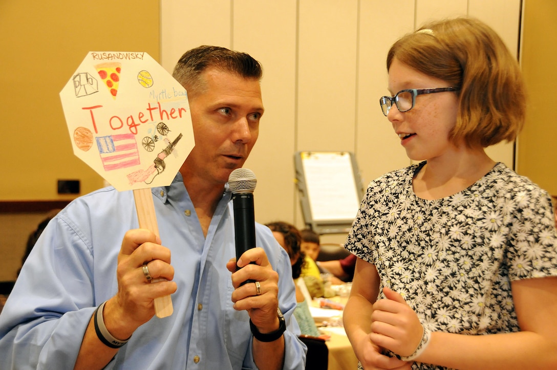 Chaplain (Capt.) Charles Ross, currently assigned to the U.S. Army Reserve’s 403rd Civil Affairs Battalion, listens July 21 as 10-year-old Ellie Rusanowsky explains her family sign during a 99th Regional Support Command Strong Bonds family event at the Kalahari Resort in Pocono Manor, Pennsylvania.  Strong Bonds is a unit-based, chaplain-led program, which assists commanders in building individual resiliency by strengthening the Army Family. The core mission of the Strong Bonds program is to increase individual Soldier and Family member readiness through relationship education and skills training.