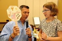 Chaplain (Capt.) Charles Ross, currently assigned to the U.S. Army Reserve’s 403rd Civil Affairs Battalion, listens July 21 as 10-year-old Ellie Rusanowsky explains her family sign during a 99th Regional Support Command Strong Bonds family event at the Kalahari Resort in Pocono Manor, Pennsylvania.  Strong Bonds is a unit-based, chaplain-led program, which assists commanders in building individual resiliency by strengthening the Army Family. The core mission of the Strong Bonds program is to increase individual Soldier and Family member readiness through relationship education and skills training.