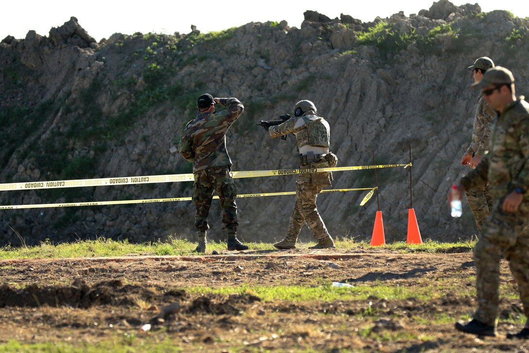 A member of the U.S. special operations team, center right, fires his weapon at a target during the Critical Task Evaluation 1 event at Vista Alegre in Villa Hayes, Paraguay, July 17, 2017, part of Fuerzas Comando 2017. Army photo by Sgt. Christine Lorenz